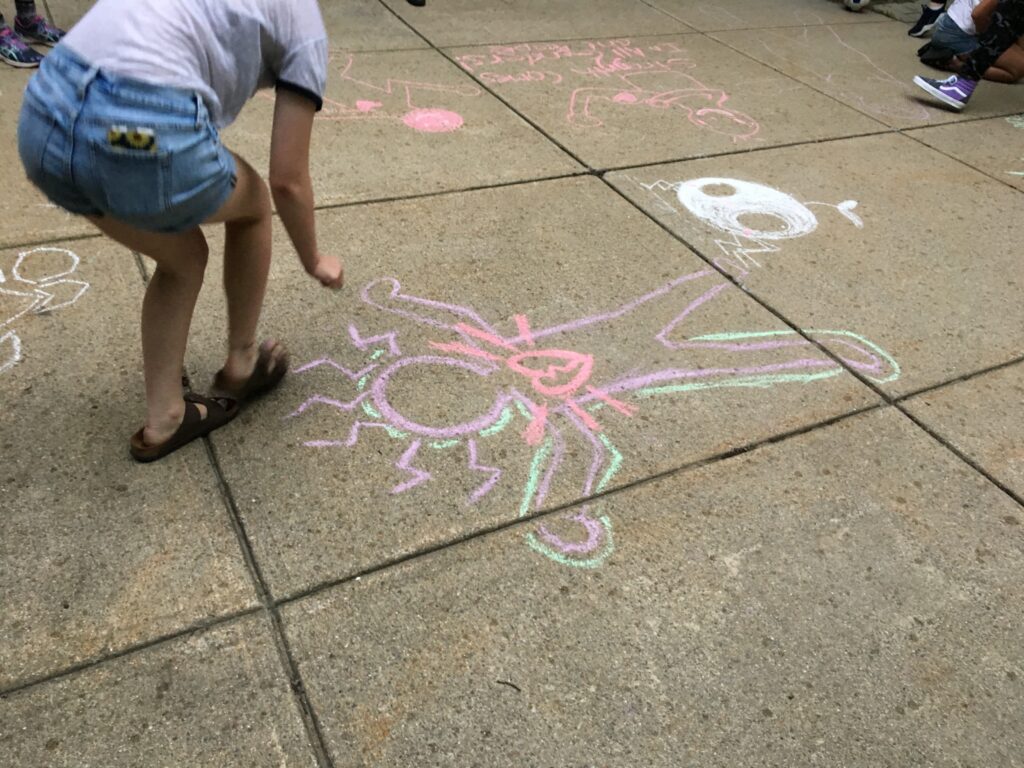 Youth drawing with sidewalk chalk